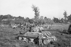 British_infantry_and_Sherman_tanks_wait_to_advance_at_the_start_of_Operation_Goodwood_Normandy_18_July_1944._B7513